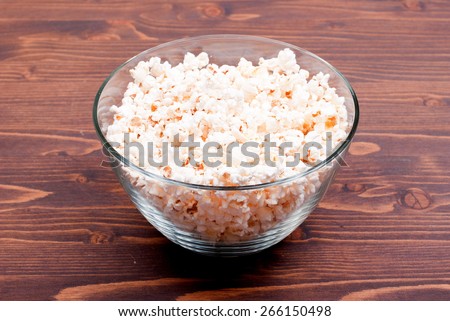 Popcorn in a large bowl, standing in the middle of the table, side view