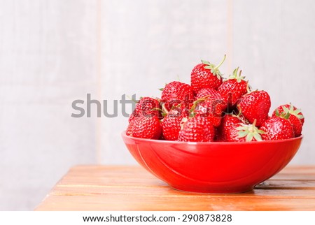 Strawberry red plate on  table, side view