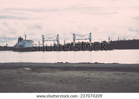 cargo ship is leaving port sailing away. riga. latvia - retro, vintage style look