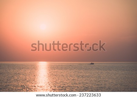 boat in the sunset in the sea with reflections and clouds - retro, vintage style look