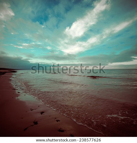 baltic beach in fall with clouds and waves towards deserted dunes. cloudy day - vintage 80\'s retro color film look