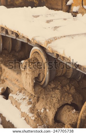Detail of tractor track in construction site with dust and snow - aged photo effect, vintage retro