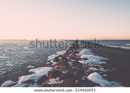 sunset over frozen sea with ice blocks and dramatic colorful sky - vintage retro grainy film effect
