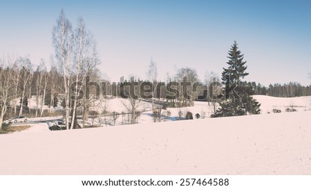 snowy winter landscape with snow covered trees and blue sky - retro vintage effect