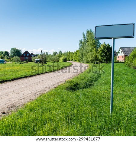 empty road with sign for village name in country. square image.