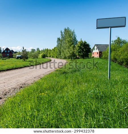 empty road with sign for village name in country. square image.