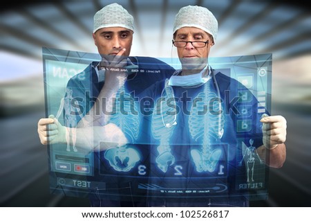 Doctors in a medical facility looking at digital screen