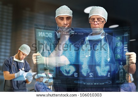 Doctors in a medical facility looking at digital screen