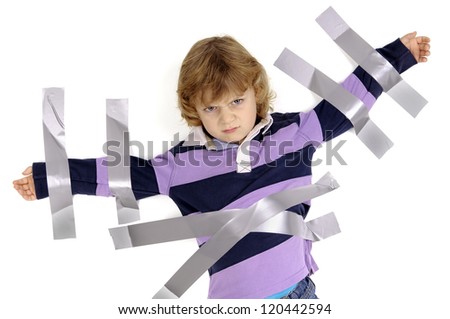 Young angry boy glued to the wall with duct tape