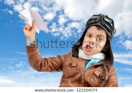 Young boy pilot flying a paper plane