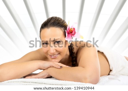 Beautiful woman in a stone massage at beauty spa salon. Recreation therapy.