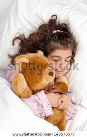 Beautiful young girl in bed with teddy bear