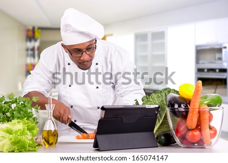 Male chef with fruits and vegetables and tablet for recipe