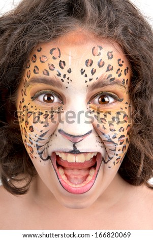 Beautiful young girl with face painted like a leopard