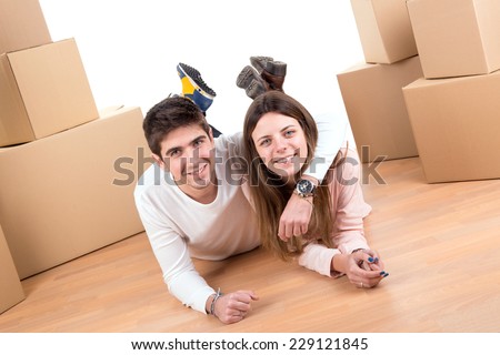 Happy couple with boxes moving into new home apartment