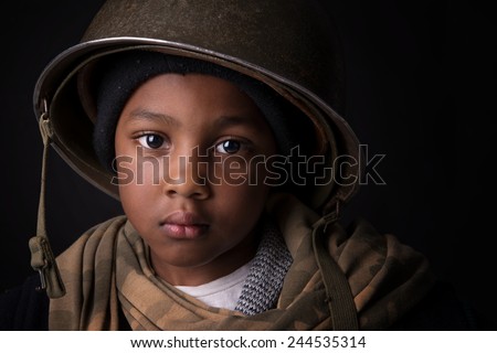 Young boy soldier portrait in a dark background