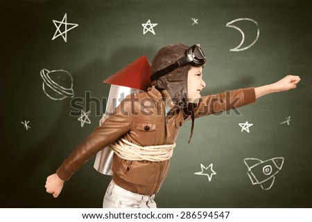Young boy with home made rocket ready for adventure in classroom