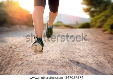Woman\'s legs running outdoors at sunset hour