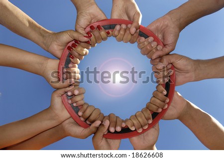 Several hands holding a disc together