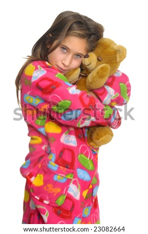 Beautiful young girl in pajamas posing with teddy bear against a white background