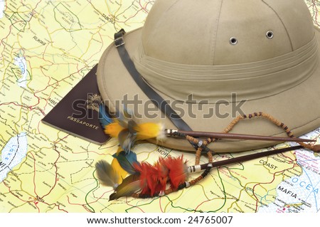 Explorer\'s hat and passport over map