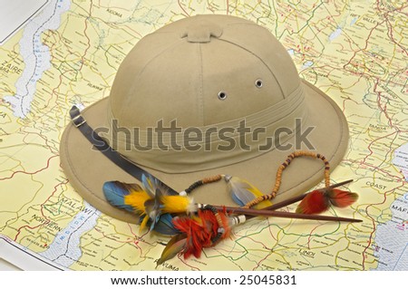 Explorer\'s hat and feathers over map