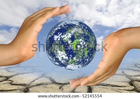 Hands with earth globe  over a dry soil and sky background