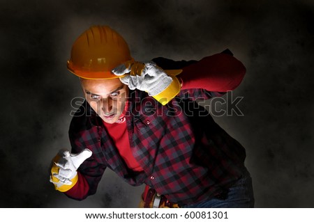Surprised constructor worker looking at a light in a dark background