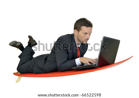 Young businessman laying in a surf board with laptop