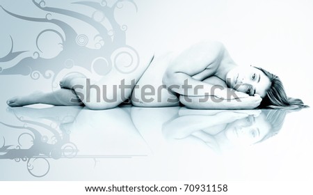 Beautiful pregnant naked woman posing laying down with reflection
