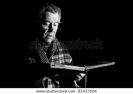 Senior man holding a very old book  in black & white