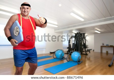 Large fitness man with weight scale in the gym