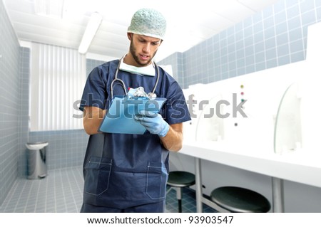 Young doctor in uniform writing in a pad