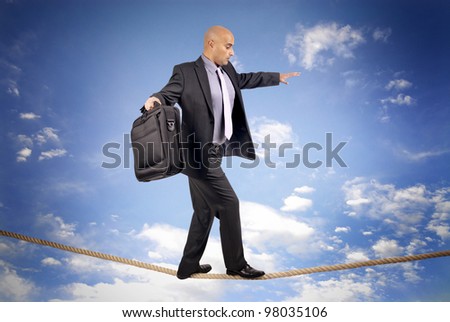 Businessman walking a rope in despair