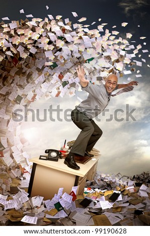 Businessman surfing in a sea of papers and files