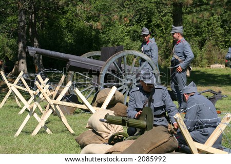 Soldiers operating a machine gun and a cannon in a military show from first world war