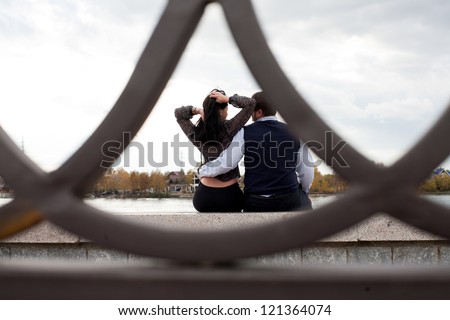 Photographer peeking behind a pair of lovers