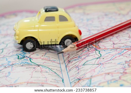 Toy car on a road atlas. The concept of travel planning.