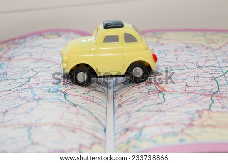 Toy car on a road atlas. The concept of travel planning.
