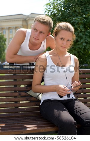 A pair of young people listen to music