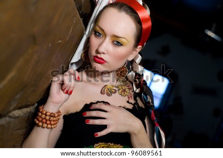 girl in the Russian national clothes and body painting on the body