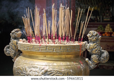 stock-photo-burning-incense-sticks-at-a-buddhist-temple-59661811.jpg