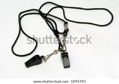 Two black coach whistles against a white background.