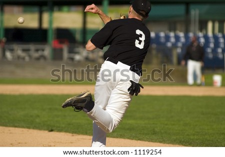 A high school baseball player works on turning the double play from third base.