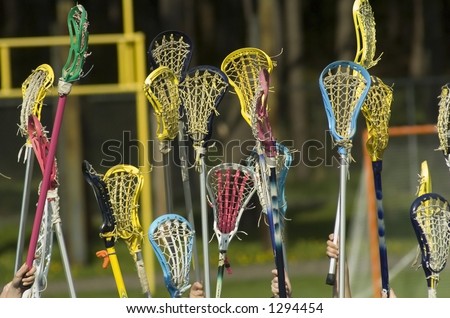 Women\'s Lacrosse sticks held high