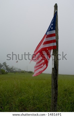 American flag hanging on a wooden post at the waterfront