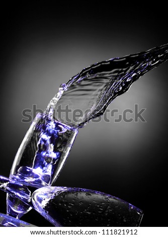 beautiful composition of water bursts with wine glasses