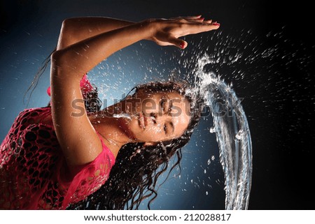 beautiful brunette with long hair plays with splashes of water. splashes of water. active movement of the water.
