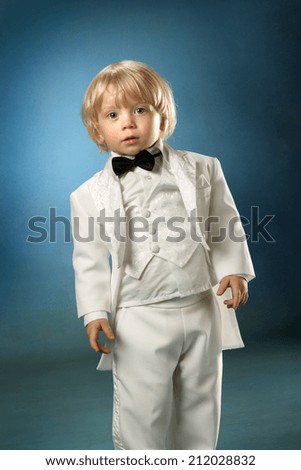 little boy in a white suit mop cleans the floor. black bow tie. baby goes directly