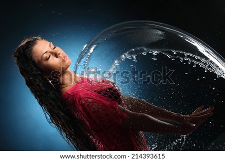 beautiful brunette with long hair plays with splashes of water. splashes of water. active movement of the water.